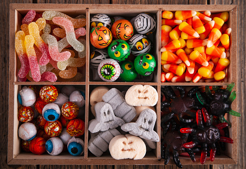 Halloween variety of sweets in a wooden box on a vintage wooden table