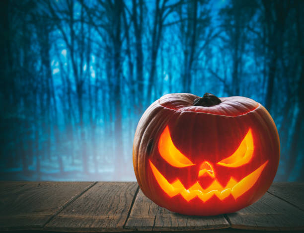 istock Pumpkin Burning In A Spooky Forest At Night - Halloween Background 1277650096