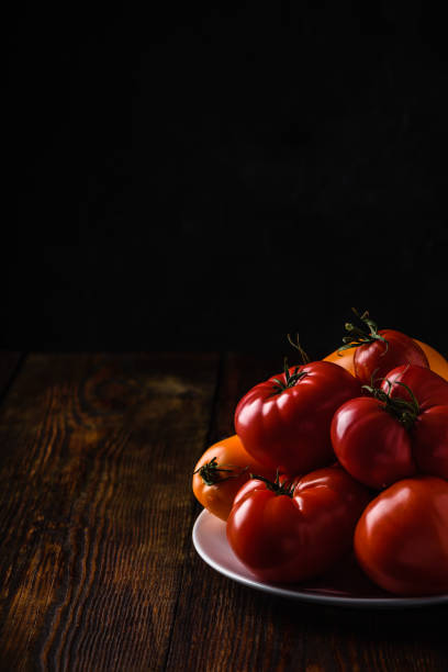 istock Fresh red and yellow tomatoes on plate 1277654120