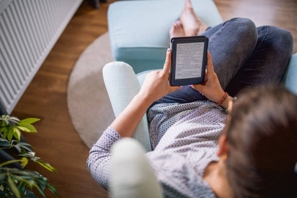 istock Unrecognizable Women Relaxing At Her Home And Reading A Book From Her E-Reader 1277659181