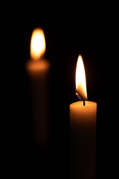 istock Two isolated burning yellow candles in the dark 1277659604