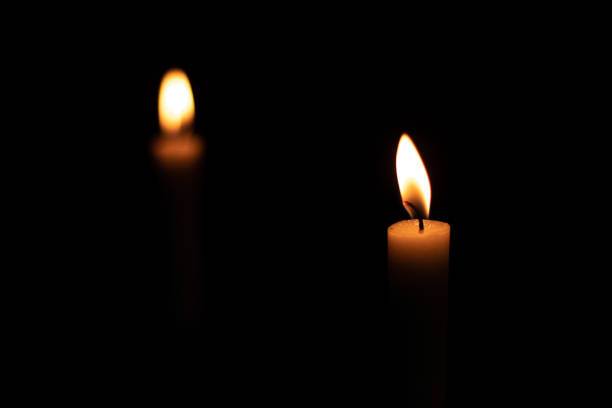 istock Two isolated burning yellow candles in the dark 1277659605