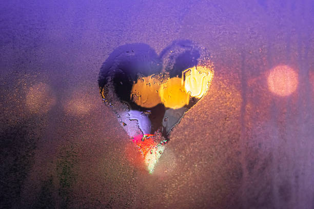 Photo of Close-up drawn heart on a foggy wet window