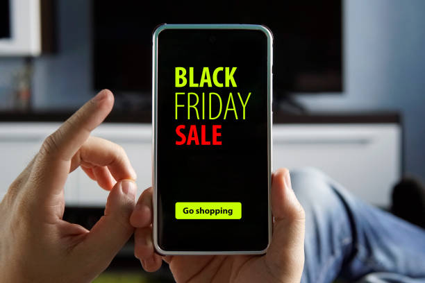 istock guy makes purchases through mobile app without leaving home. Convenient service. People sale, consumerism, advertisement concept - close up of man hand holding smartphone with black friday inscription 1277659878