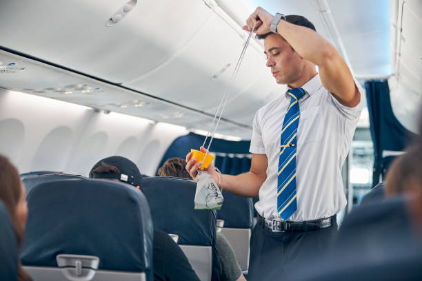 istock Man with oxygen mask demonstrating safety procedure prior to passenger airplane flight 1277665852