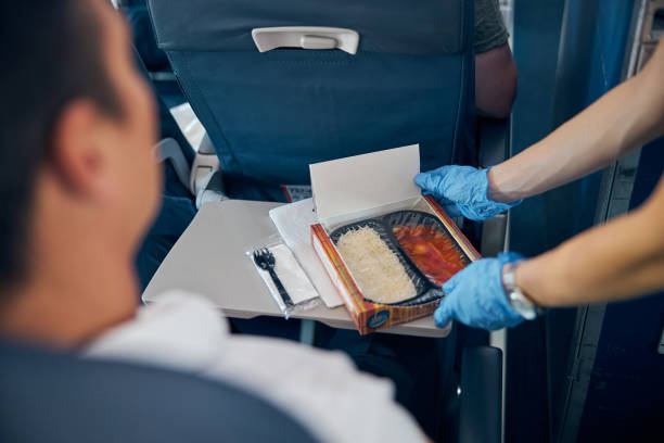istock Air hostess putting meal on table gently in front of man 1277665873