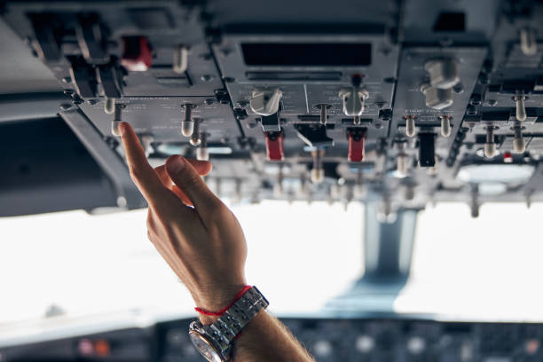 Close up portrait of man hand with watch on it while pushing on the dashboard of modern civil passenger airplane