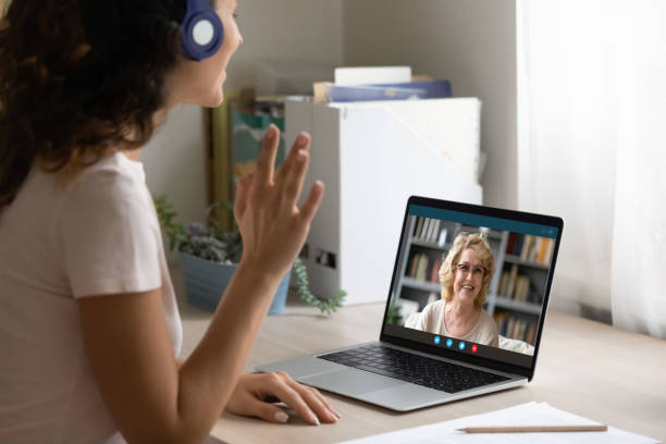 istock Smiling woman wave talking on video call on laptop 1277668209