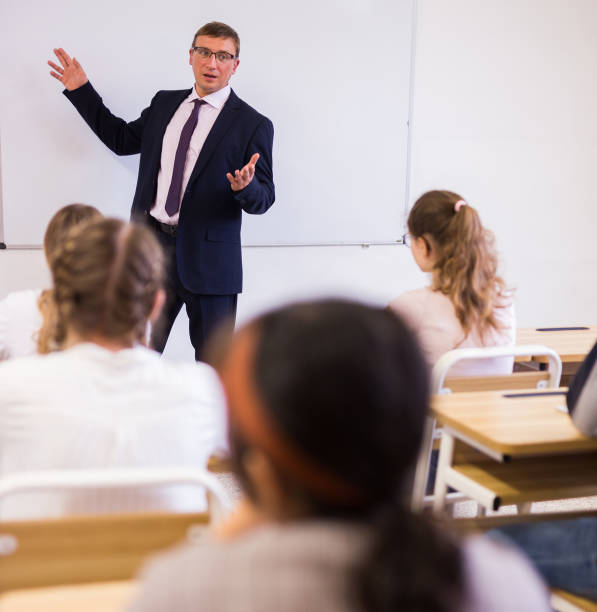 istock Male teacher lecturing to students at classroom 1277681811