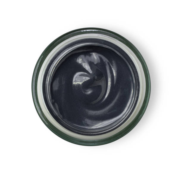 istock Clay or charcoal mud cream in jar isolated on white background. 1277686781