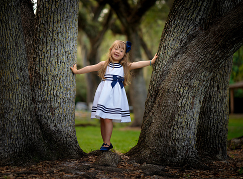 5 years old girl having her pictures taken among trees