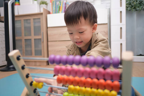 istock Cute asian kindergarten using the abacus with beads to learn how 1277698963