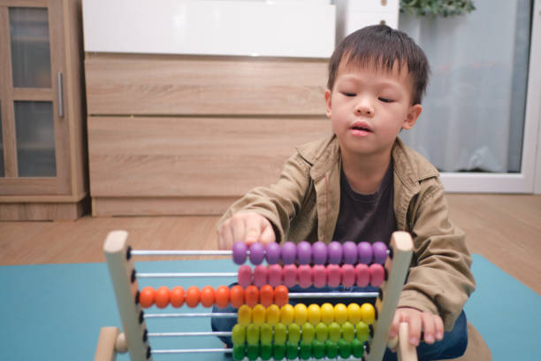 istock Cute asian kindergarten using the abacus with beads to learn how 1277698966