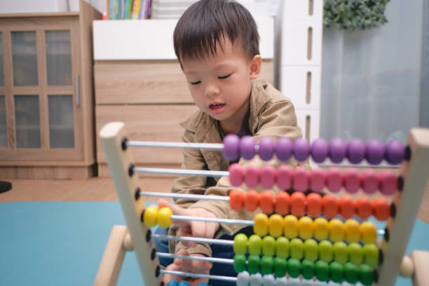 istock Cute asian kindergarten using the abacus with beads to learn how 1277698967