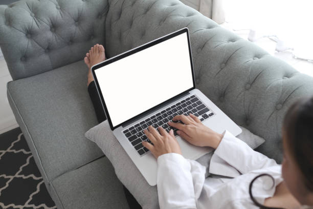 istock Satisfied woman relaxing on comfortable couch and using laptop with white screen at home. 1277705215