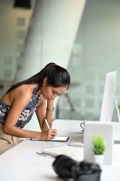 istock Young female freelancer writing her idea on digital tablet and using stylus pen in modern office. 1277705714