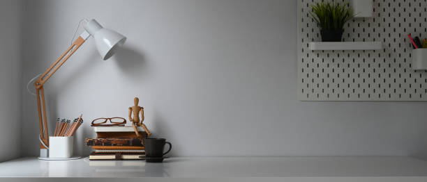 istock Workspace with books, lamp and creative supplies on white table with dark light. 1277705747