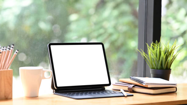 istock Cropped shot of tablet with smart keyboard, coffee cup, pencils and book on workspace table.Blank screen for graphics display montage. 1277705754