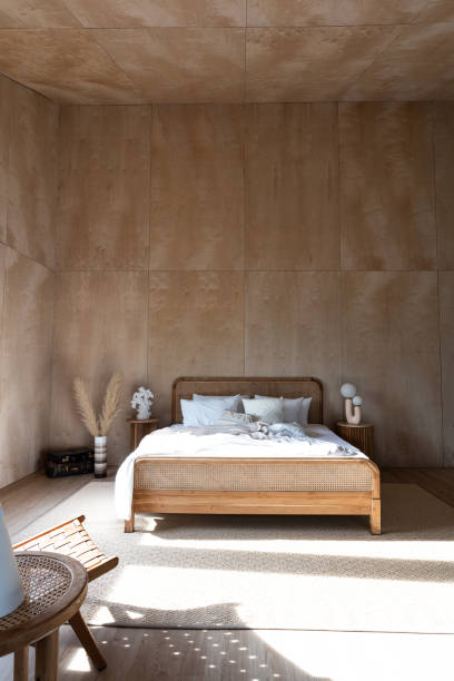 istock Stylish Bedroom corner with rattan headboard and bed with soft pillows setting with white pillows plywood wall on the background / cozy interior design / modern interior 1277715767
