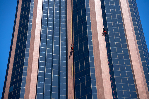 Window cleaners are working on high rise building in North Sydney, Australia. October 2020