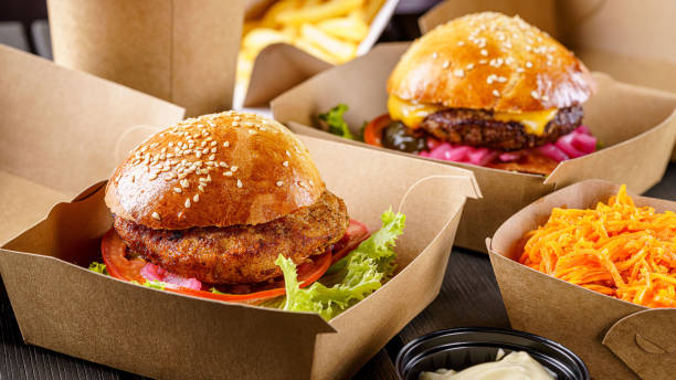 street food. fleischschnitzel-burger sind in papierkisten. lebensmittellieferung. - essen zum mitnehmen stock-fotos und bilder