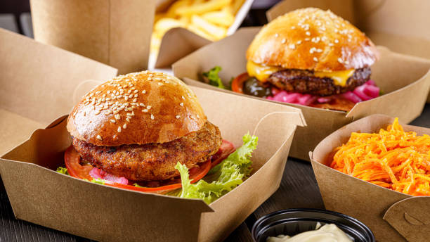 street food. meat cutlet burgers are in paper boxes. food delivery. - burger king imagens e fotografias de stock