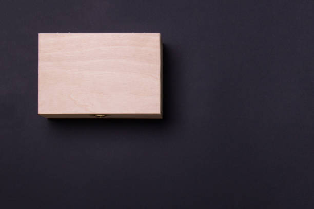 istock wood box lying on black background in left corner, top view with copy space 1277720315