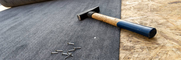 Close-up of roofing felt, hammer and nails stock photo