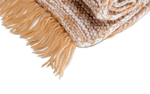 Close-up of a woolen knitted scarf (rolled) on a white background.