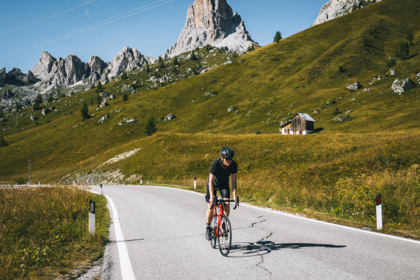 istock Road biker ascends mountain road in the morning 1277726643