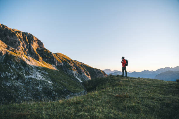 istock Hiker traverses alpine meadow at sunrise 1277728357