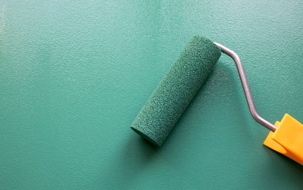 Paint roller with green colour on painted wooden surface. Chalk board Paint roller with green colour on painted wooden surface. Chalk board. Painting and renovation. rolling photos stock pictures, royalty-free photos & images