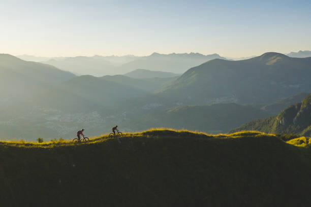 istock Mountain bikers ride up grassy mountain ridge 1277728831