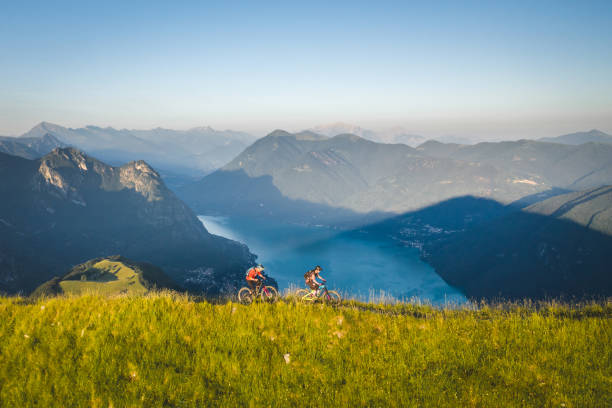 istock Mountain bikers ride along grassy mountain ridge 1277729372