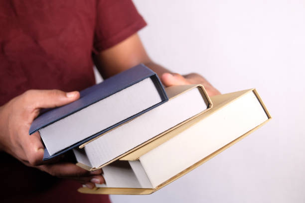 istock hand holding stack of books on white background 1277732518