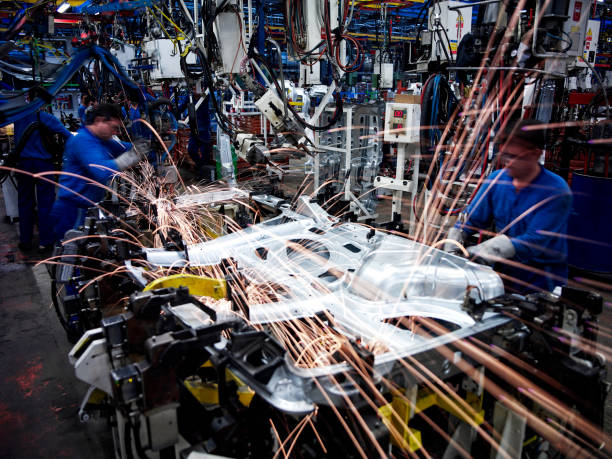 Welders in car factory Welders welding a steel car part in a car factory with sparkles coming out production line automobile industry car plant car stock pictures, royalty-free photos & images