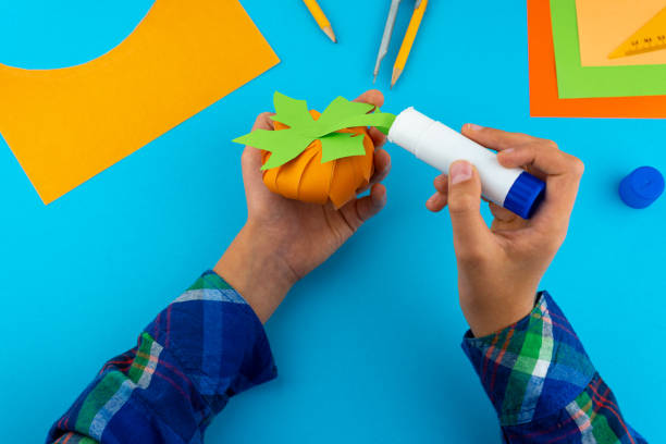 istock Step 8. Step by step instructions on how to make a pumpkin from colored paper or cardboard. Do it yourself. Glue, a ruler, compasses, scissors. A DIY craft for children. Decoration for the Halloween 1277735876