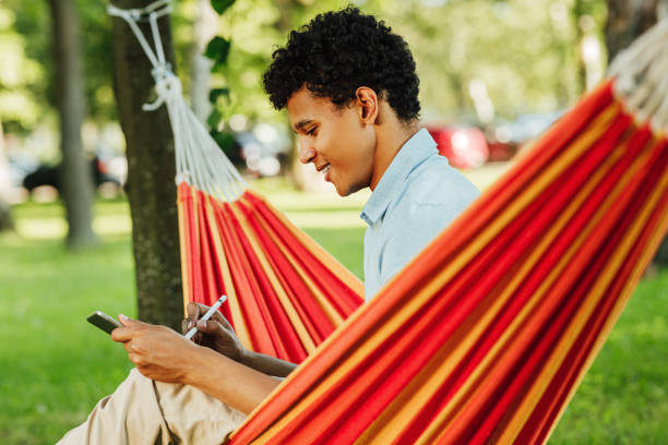 istock Young smiling guy drawing on digital tablet in park 1277737457