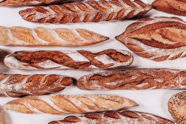 istock Bakery bread - fresh rustic crusty loaves of bread and baguette on white background.  (top view, flat lay). 1277737623