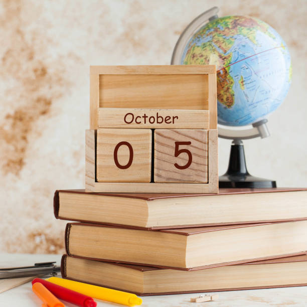 wooden calendar of october 5 on the background of a globe and stationery. teacher's day greeting card. - apple for the teacher imagens e fotografias de stock