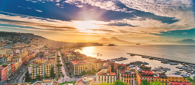 Golden sunrise over the Bay of Naples towards Mount Vesuvius in the background. Naples, is the regional capital of Campania and the third-largest city of Italy, after Rome and Milan, with a population of almost 1million. It's the second-most populous metropolitan area in Italy and the 7th-most populous urban area in the European Union.