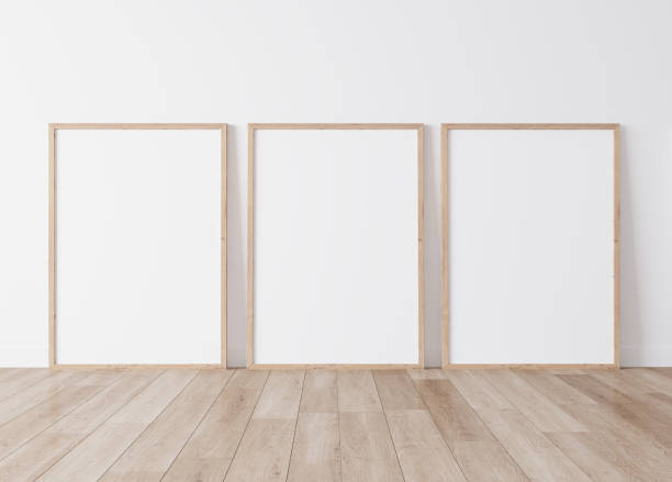 istock Three vertical wooden frames standing on parquet floor with white background, minimal frame mock up interior 1277741538