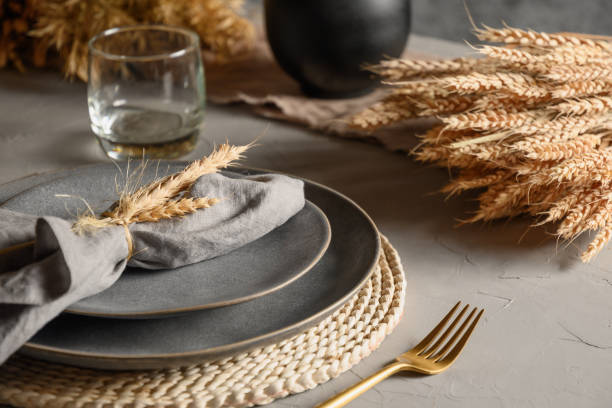 istock Autumn table setting with dry yellow oak leaves, fall decoration on grey. Thanksgiving day 1277742615