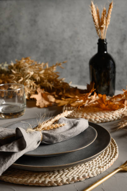 istock Autumn table setting with dry yellow oak leaves, fall decoration on grey table. Thanksgiving day 1277742616