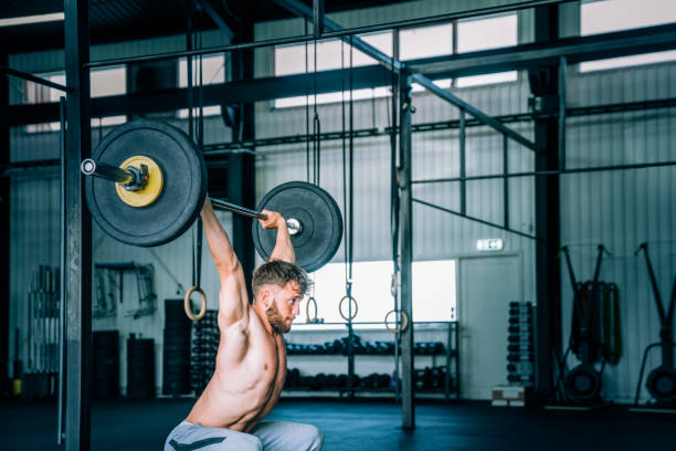 istock Man exercising with barbell in cross training gym 1277745190