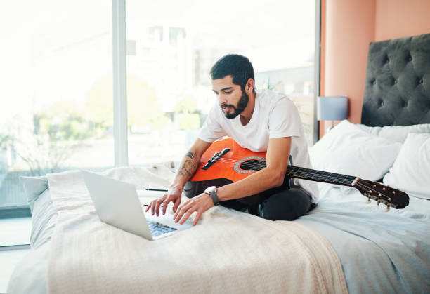 istock Learning how to play the guitar from home 1277745970