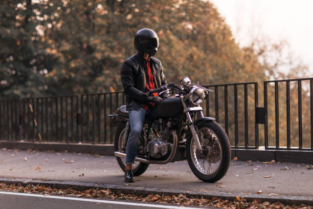 Male biker wearing a leather jacket, sitting on his motorbike, getting ready for a joy ride