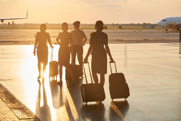 Bright evening sunlight in the airport and crew members walking