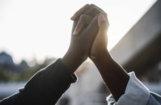 los negros se tomaron de la mano durante la protesta por el no racismo - concepto de empoderamiento e igualdad de derechos - antirracismo fotografías e imágenes de stock