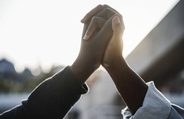 Black people holding hands during protest for no racism - Empowerment and equal rights concept Black people holding hands during protest for no racism - Empowerment and equal rights concept peace sign gesture photos stock pictures, royalty-free photos & images